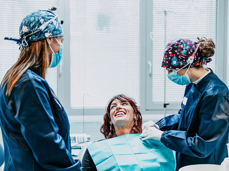 Dentisti con paziente che sorride